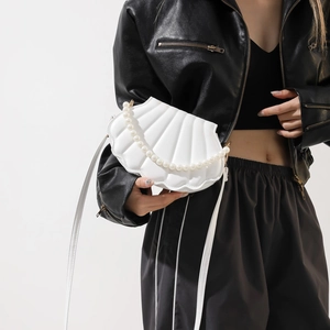 Detailed view of white shell-shaped crossbody bag with pearl chain and textured PU leather