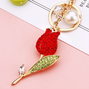Macro detail of tulip keychain with red rhinestones, large white pearl and gold ring
