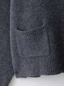 Gros plan du cardigan en laine gris anthracite montrant la texture et la poche côtelée