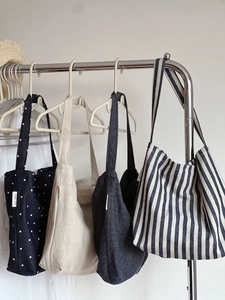 Detail view of four canvas shoulder bags in denim, stripes, and polka dot designs