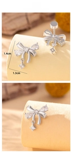 Macro detail of silver bow earrings with sparkling cubic zirconia and pear-shaped drop