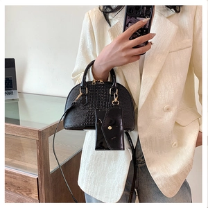 Detailed view of black crocodile pattern shell bag with small detachable coin purse accessory