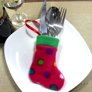 Pink polka dot Christmas sock cutlery holder with metal utensils on a white plate