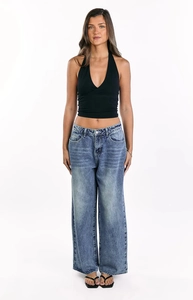 Full view of women's washed blue wide-leg jeans paired with a black halter top