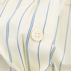 Vertical blue striped beige shirt featuring cotton texture and a white round button detail