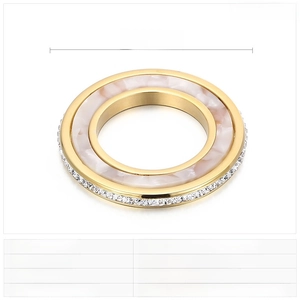 Détail d'un pendentif rond en acier inoxydable avec nacre blanche et strass incrustés