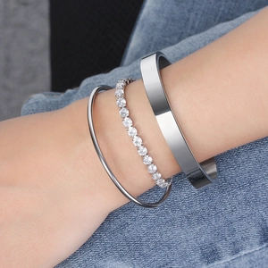 S925 silver bangles and sparkling zircon tennis bracelet set on denim background