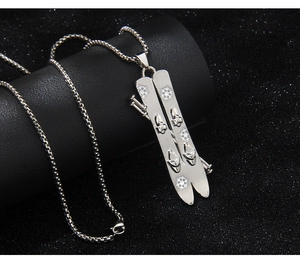 Macro detail of silver snowboard pendant on box chain over dark premium texture