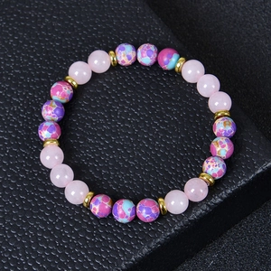 Detailed close-up of 8mm rose quartz and emperor stone beads on a black leather surface