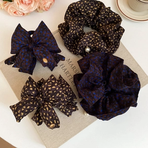 Close-up of bow hair scrunchies with polka dots, pearls and golden love charms