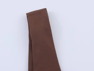 Détail de la texture du tissu marron et des coutures de qualité sur la robe midi