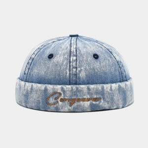 Retro washed denim brimless docker cap with Conqueror embroidery in light blue snowflake wash