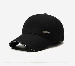 Detail view of the black thermal baseball cap with fashion metal tag and printed brim
