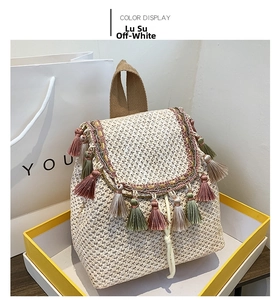 Detail of bohemian straw backpack with colorful tassels and ethnic woven fringe trim