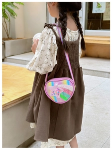 Photo extérieure d'un enfant portant un sac étoile à paillettes rose avec sangle arc-en-ciel