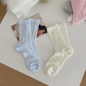 Flat lay of hollow lace mesh crew socks in pastel blue and beige with breathable patterns