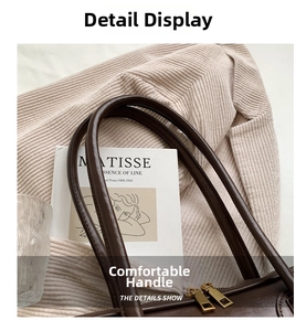 Close-up of retro brown leather bag featuring dual matte gold metal zippers and handles