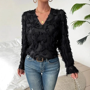 Detail shot of black elegant blouse featuring textured feather fringe fabric and V-neckline