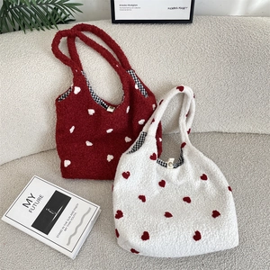 Detail of plush tote bags with heart patterns, soft faux fur texture, and checkered lining