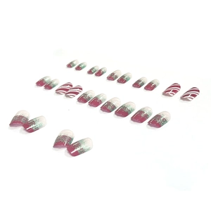 Christmas matte press-on nails with red candy cane stripes and glitter gradient design