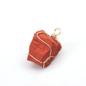Macro view of a handmade wire-wrapped irregular red raw crystal stone pendant