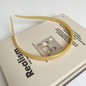 Macro-opname van een dunne gele acetaat hoofdband rustend op een boek-decor