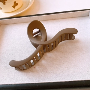 Detailed macro view of a matte brown shark hair claw clip in a linen-lined gift box