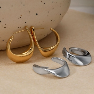 Boucles d'oreilles créoles irrégulières polies en or et argent sur céramique