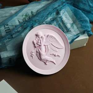 Detail of pink round angel relief tray with intricate carving for home decor