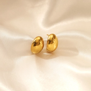 Polished 18K gold plated stainless steel bean stud earrings on silk background