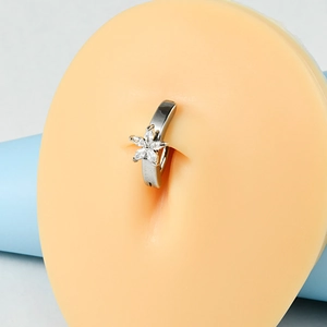 Macro detail of silver flower belly button ring with white zircon on a silicone model