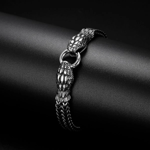 Détail d'un bracelet tête de serpent double en acier argenté sur support cylindrique noir