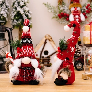 Gnomi di Natale con cappelli rossi a maglia e bastoncino di zucchero in scena festiva