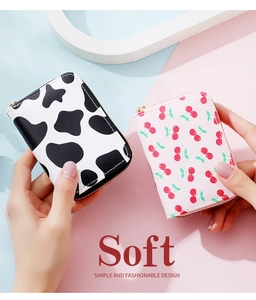 Detail of soft accordion wallets with cow print and cherry patterns for women