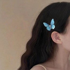 Elegant blue butterfly hair clip with rhinestones and pearl tassels on wavy hair
