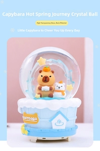 Close-up of a blue Capybara snow globe with glass dome and resin base on a clean background