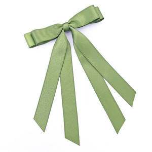 Detail of double-layered green satin ribbon hair clip with long fluttering streamers