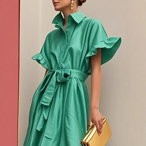 Détail de la robe en satin vert avec élégantes manches volantées et ceinture assortie