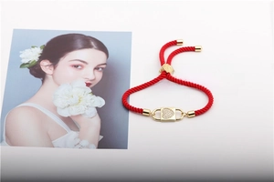Macro detail of red woven rope bracelet with gold zircon heart lock charm and adjustable clasp