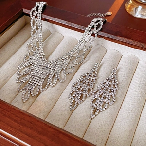 Detailed view of silver-tone V-shape rhinestone necklace and earrings in a velvet box