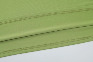 Macro view of reinforced double-needle stitching and light green knit fabric texture