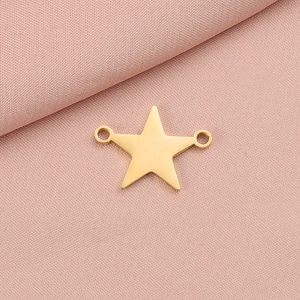 Detail view of double-hole gold star pendant for DIY jewelry on pink fabric
