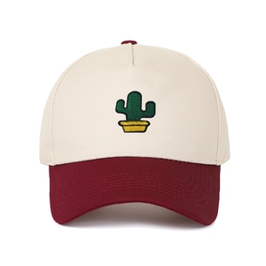 Détail de la broderie cactus sur une casquette de baseball beige et bordeaux bicolore