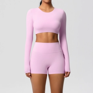 Detail of pink long sleeve yoga set showing seamless fabric and high waist fitness shorts