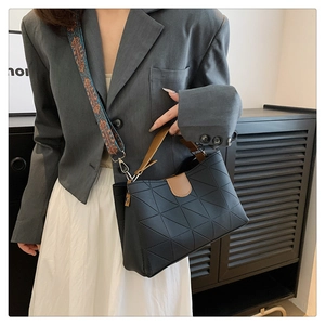 Chic black bucket bag with brown handles and a colorful patterned ethnic wide strap detail