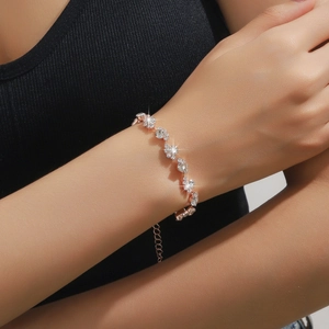 Dettaglio del bracciale in oro rosa con zirconi ondulati e catena di estensione regolabile
