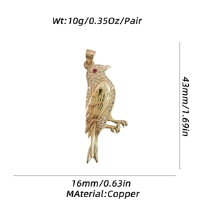 Detailed macro view of gold hummingbird pendant with zircon inlay and red eye accent