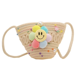 Beige straw woven crossbody bag for kids featuring a floral smiley face and pom poms