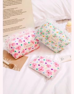 Macro shot of quilted floral cosmetic bags with lace trim and aesthetic skincare props