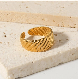 Macro shot of 18k gold vintage open ring with textured spiral grooves on stone